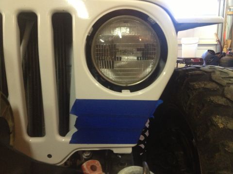 2000 Jeep TJ - Front fender of a 2000 Jeep TJ with blue tape applied near the turn signal opening.