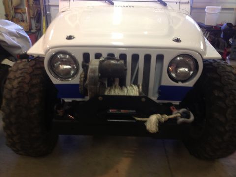 2000 Jeep TJ - This Jeep TJ features a winch and oversized tires, ready for off-road adventures.