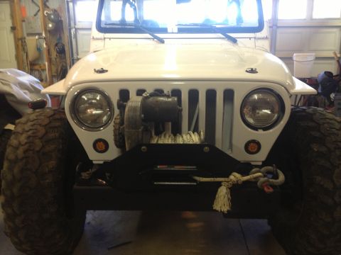 2000 Jeep TJ - Front view of a white 2000 Jeep TJ equipped with a winch and off-road tires.