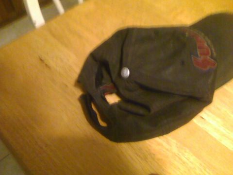 2003 Ford Crown Victoria - A dark baseball cap with a red logo rests on a wooden surface.