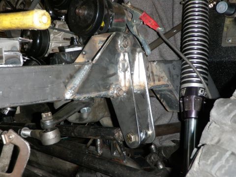 1961 International Scout 800 - Close-up view of a custom-built steering and suspension system, showing fabricated metal parts and a shock absorber.