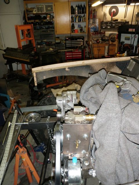 1961 International Scout 800 - Engine components are assembled on a stand in a workshop with tools and equipment visible in the background.