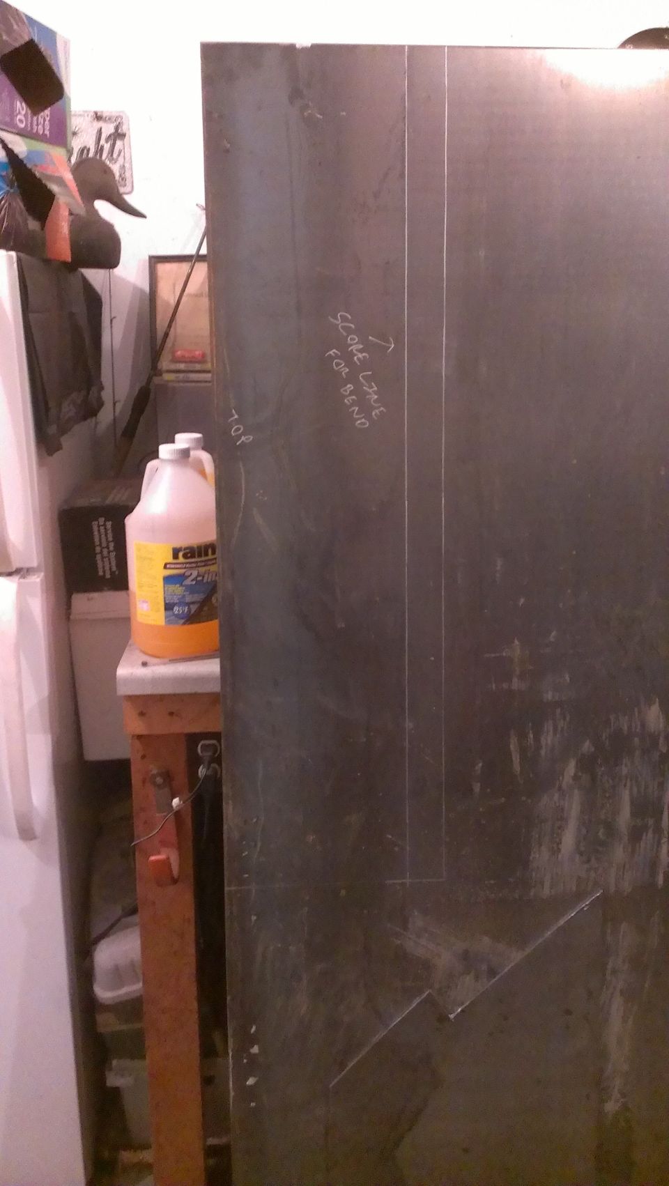 Metal panel with chalk lines and 'TOP' and 'SCORE LINE FOR BEND' markings