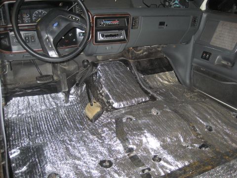 1989 Ford Bronco - The interior of a Ford Bronco is shown with soundproofing material installed on the floor and center console area.