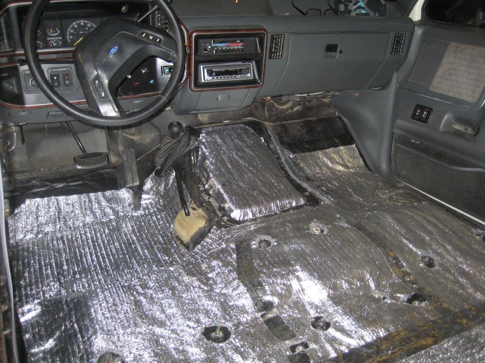 Interior of a Ford Bronco with soundproofing material laid on the floor and transmission tunnel