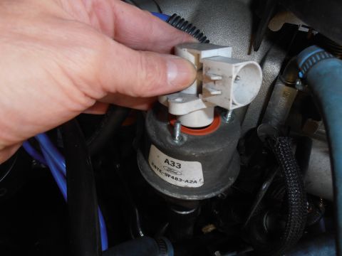 1990 Ford Bronco - A hand is shown disconnecting a Ford EVP sensor, identified by the part number F5TE-9F483-A2A.