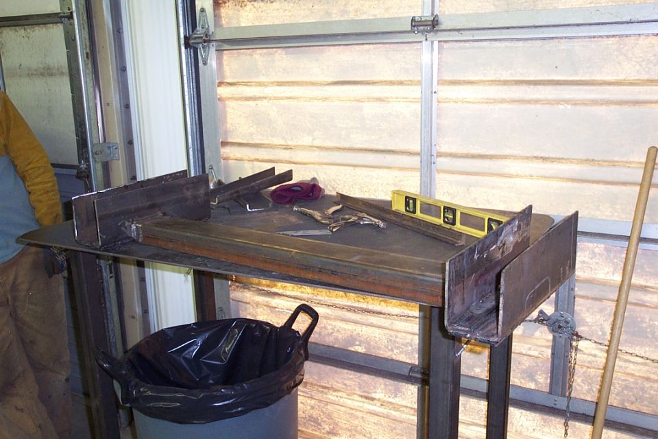 Metal workbench with yellow level and pliers in a garage