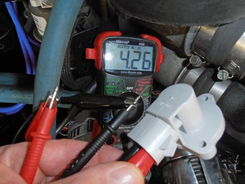 1990 Ford Bronco - A multimeter measures the resistance of an automotive sensor, showing 4.26 k ohms.