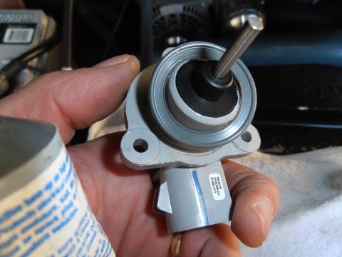 1990 Ford Bronco - Close-up of a brake master cylinder part being held, with a label indicating assembly in Mexico.