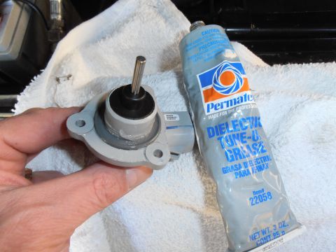 1990 Ford Bronco - A person is holding an automotive sensor next to a tube of dielectric grease, likely for maintenance.
