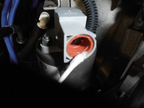 1990 Ford Bronco - Close-up of an EVP sensor, showing a red seal and a white swab being used.