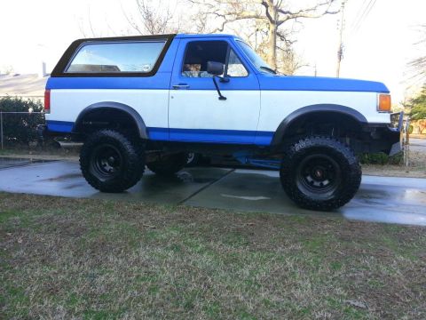1994 Ford Bronco - This lifted Ford Bronco features a two-tone paint scheme and off-road tires.
