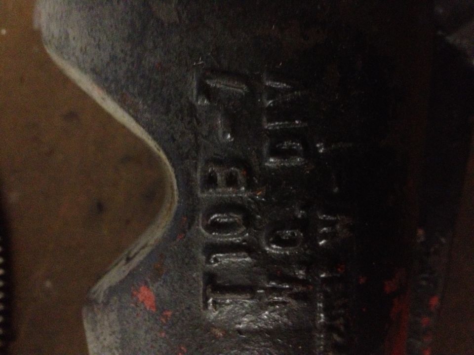 Close-up of a dark metal part with stamped numbers, including '10B' and '416'