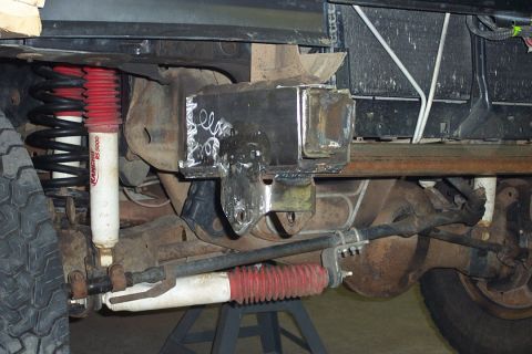 1996 Ford Bronco - Underside view of a Ford Bronco's front suspension showing a welded/fabricated steel bracket or crossmember, red Rancho RS5000 shock absorb…