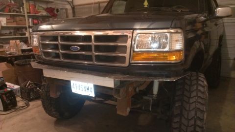 1995 Ford Bronco - This Ford truck features a prominent grille and a custom bumper, with large off-road tires visible.
