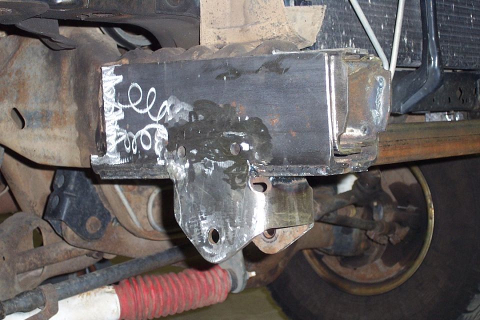 Welded steel bracket on vehicle undercarriage with fresh welds and suspension parts
