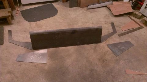 1995 Ford Bronco - Metal parts for a custom bumper project are arranged on the floor.