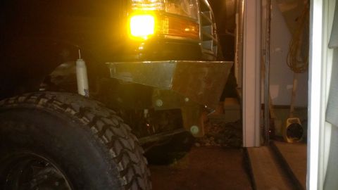 1995 Ford Bronco - A custom metal bumper is attached to the front of a 1992 Ford Bronco, partially obscured by a large tire.