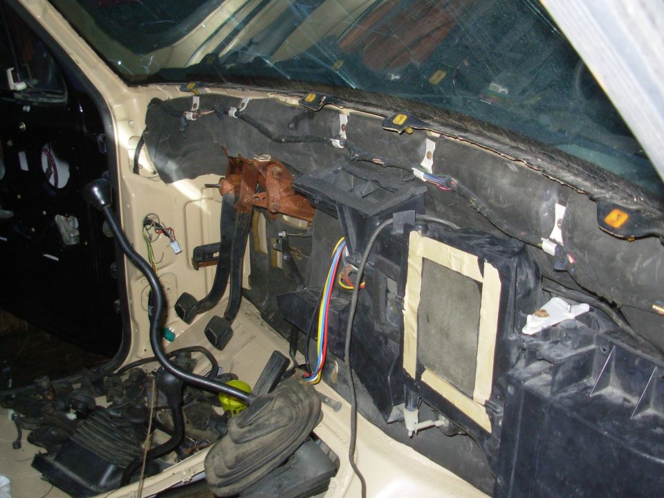 Vehicle interior with dash removed exposing HVAC box, wiring, and pedals