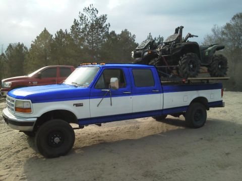 1994 Ford Bronco - This Ford F-Series truck, likely from the mid-1990s, is equipped to haul off-road vehicles.