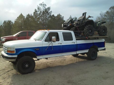 1994 Ford Bronco - Ford F-Series truck hauls two ATVs, with another truck visible in the background.