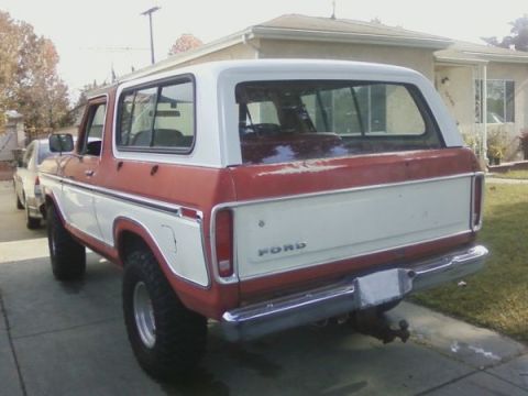 1978 Ford Bronco - The rear of a two-tone red and white Ford Bronco is shown parked in a driveway.