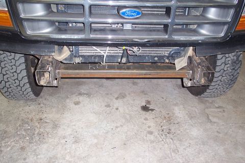1996 Ford Bronco - Front-end view of a dark green Ford truck showing the chrome grille with Ford oval emblem, exposed radiator, and a bare welded steel tube b…