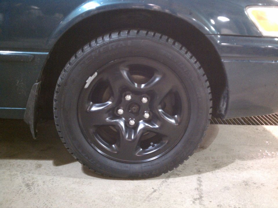 1998 Toyota Camry wheel and fender, dark green paint, black steel wheel with five spokes