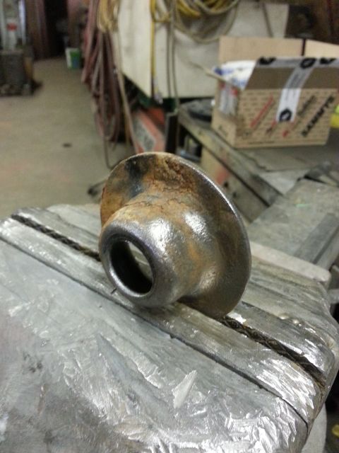 1994 Ford Bronco - A rusted metal part is held in a vise in a workshop setting.