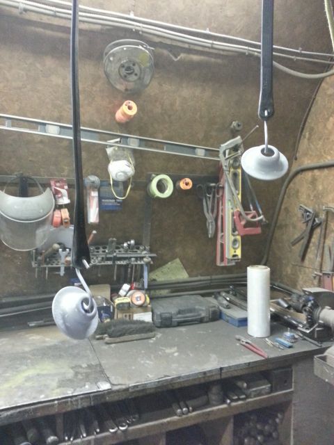 1994 Ford Bronco - A workshop scene shows a cluttered workbench with various tools and supplies, including levels, pliers, and rolls of tape.