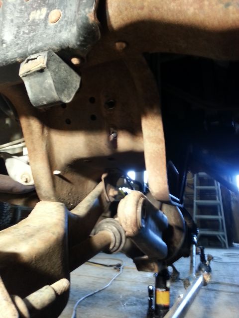 1994 Ford Bronco - The underside of a vehicle shows significant rust on its frame and suspension components.