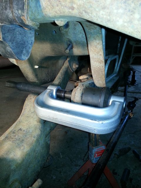 1994 Ford Bronco - A ball joint separator tool is used on a vehicle's suspension system, likely during maintenance or repair.