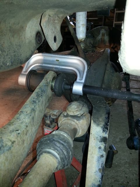 1994 Ford Bronco - Using a ball joint press tool on a vehicle's suspension system.