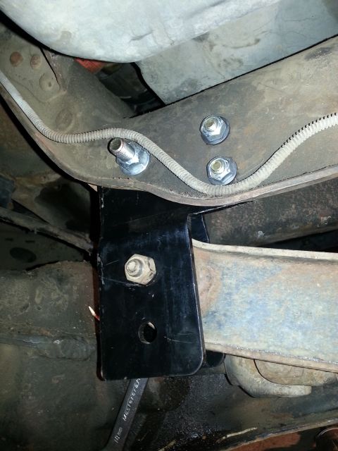 1994 Ford Bronco - A close-up view of a vehicle's undercarriage shows a newly installed black bracket and hardware.