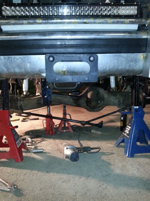 1994 Ford Bronco - Vehicle under repair, showing the underbody, suspension, and tools laid out.