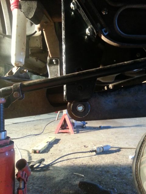 1994 Ford Bronco - Undercarriage view of a vehicle being worked on, showing suspension components and support equipment.