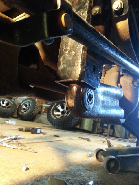 1994 Ford Bronco - Underbody view showing suspension components and multiple tires in the background, suggesting a workshop or garage setting.