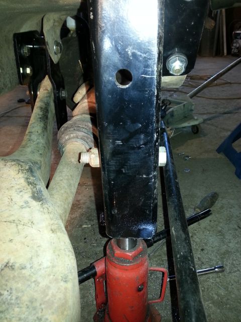 1994 Ford Bronco - Hydraulic jack supporting vehicle frame during maintenance or repair work.