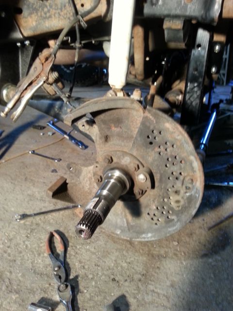 1994 Ford Bronco - Close-up of a vehicle's front suspension and braking system components during repair.
