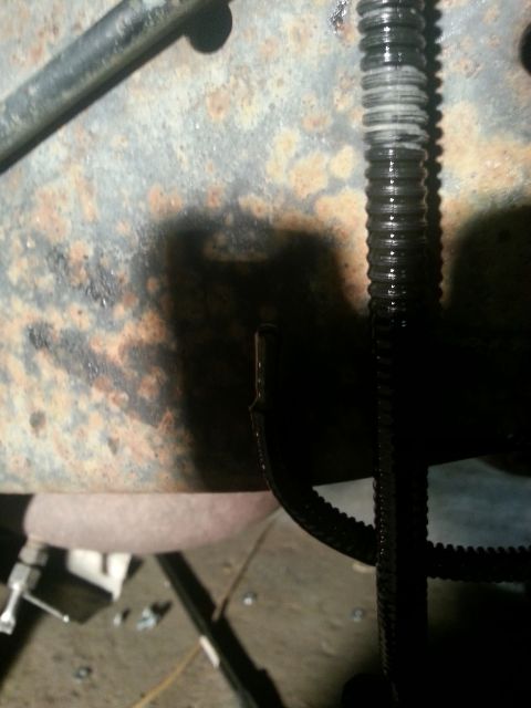 1994 Ford Bronco - Detail of a corroded vehicle frame showing a wiring harness and exposed wire.