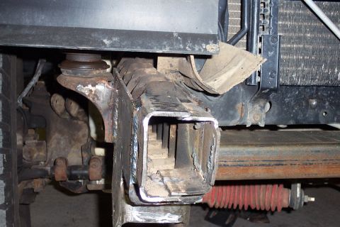 1996 Ford Bronco - Close-up underside view of a welded square-tube receiver hitch mounted to a vehicle frame crossmember, showing fresh weld beads and surroun…