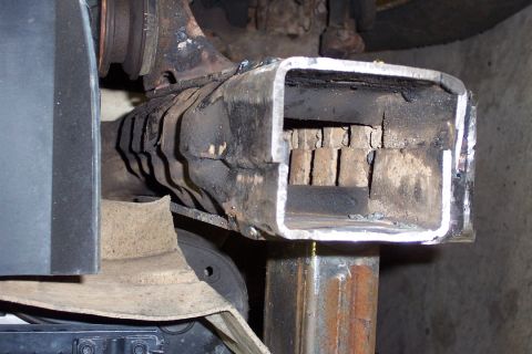 1996 Ford Bronco - Close-up of a fresh weld joining a new rectangular steel tube section to an existing frame rail, showing the cut end with visible internal…