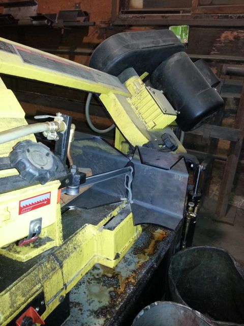 1994 Ford Bronco - Metal cutting bandsaw in workshop setting, showing cutting mechanism and motor.