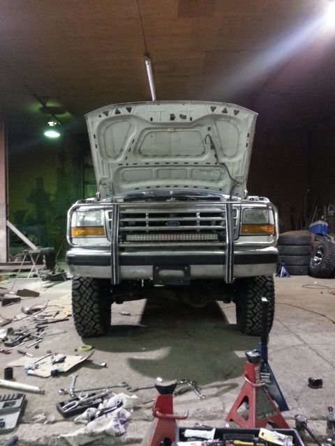 1994 Ford Bronco - This Ford F-Series truck is in a garage with its hood open, showing a bull bar and LED light bar on the front.