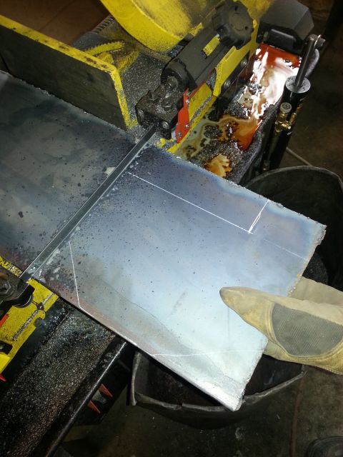 1994 Ford Bronco - A metal sheet is being cut by a band saw in a workshop.