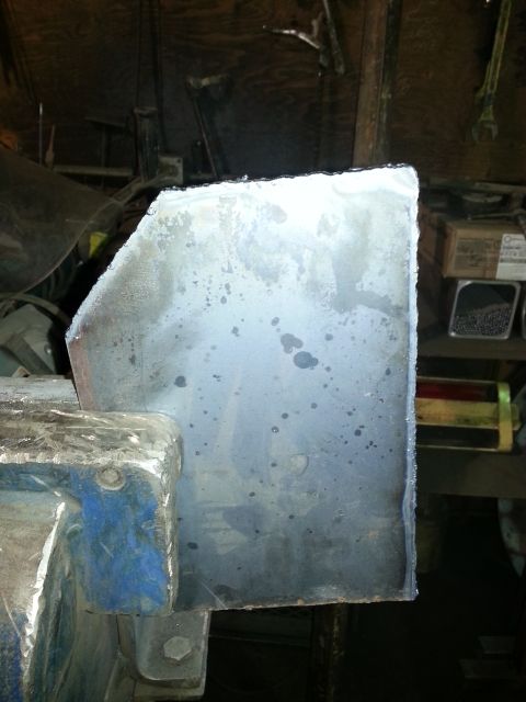 1994 Ford Bronco - A metal component is secured in a vise, ready for work in a cluttered garage setting.