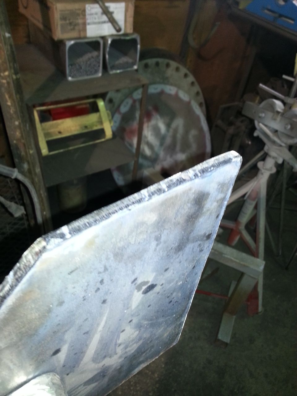 Metal part in a workshop with Supermotors.net logo