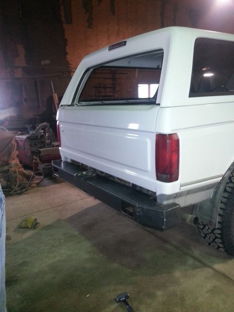 1994 Ford Bronco - Rear view of a white SUV, possibly a Ford Bronco, in a workshop setting.