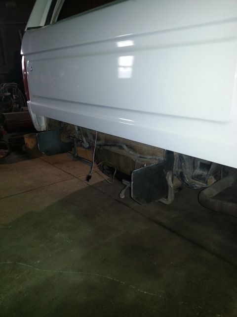 1994 Ford Bronco - The rear bumper area of a white 1994 Ford Bronco shows exposed frame components and wiring, suggesting it is undergoing maintenance or modi…