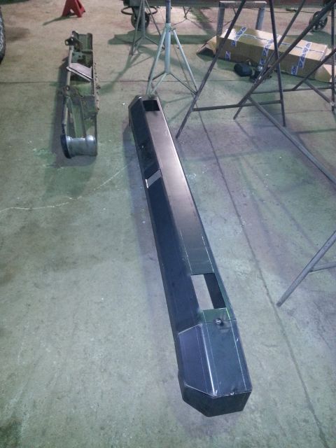 1994 Ford Bronco - Aftermarket bumpers are laid out on the floor, possibly for installation or modification.